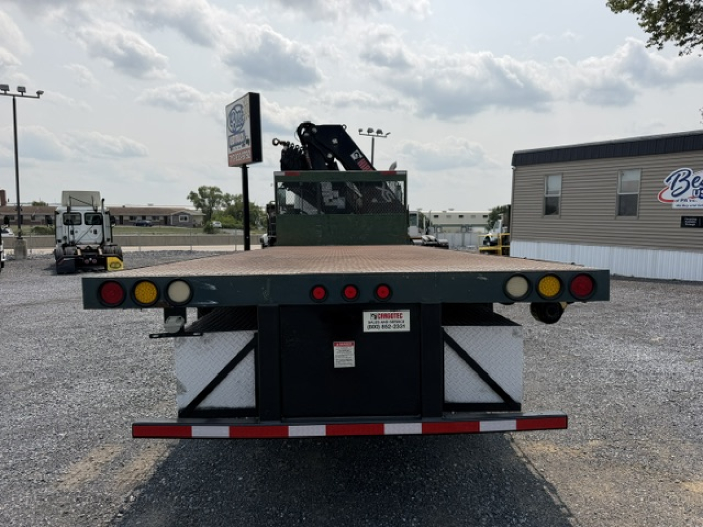 Flatbed tow truck bed of a 2022 International 7600 SBA Work Star crane truck showing rear deck with taillights, bumper, and small white label plate.