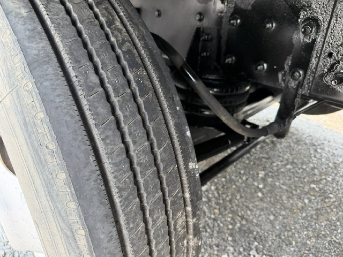 Truck wheel and suspension area of a 2022 International 7600 SBA Work Star showing tire tread and undercarriage components.