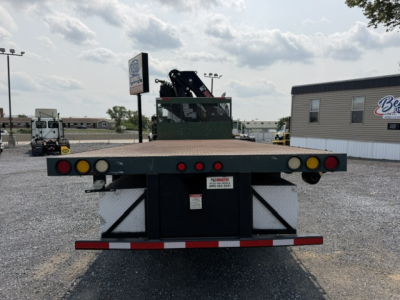 Flatbed tow truck bed of a 2022 International 7600 SBA Work Star crane truck showing rear deck with taillights, bumper, and small white label plate.