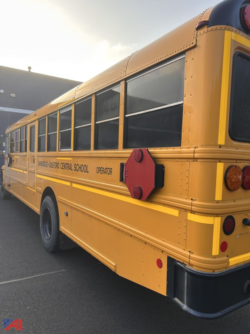 School bus rear-side view showing yellow body with black-tinted windows and red emergency hatch; text along side reads SCHOOL BUS O.D. CENTRAL SCHOOL OPERATOR.