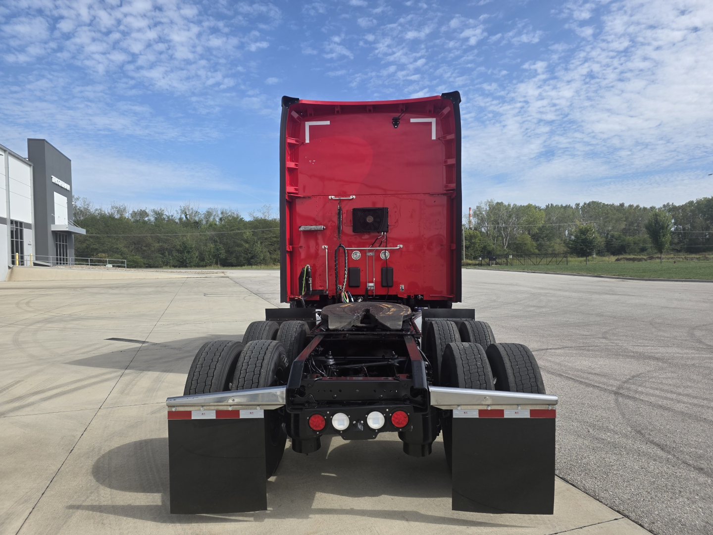 Kenworth T680 rear view showing fifth wheel and dual rear axles with red sleeper cab