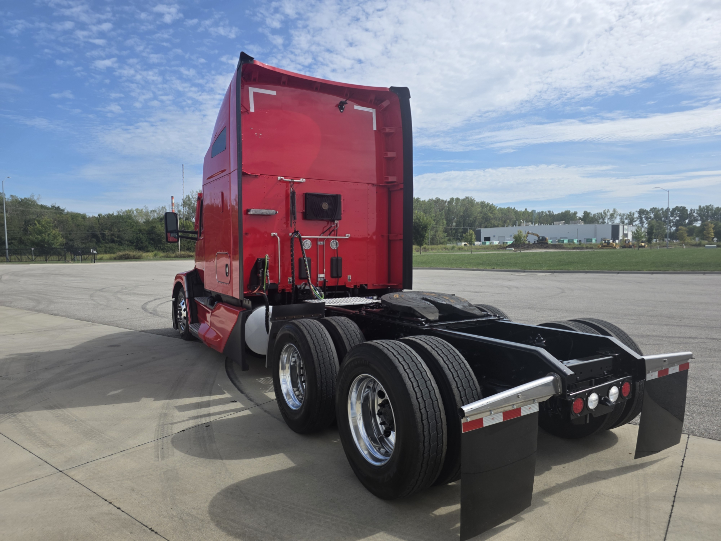 Kenworth T680 tractor rear and cab view showing red sleeper with dual rear axles and trailer connection area.