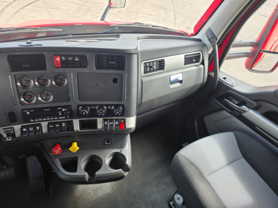 Kenworth T680 interior dash panel showing gauges, controls, cup holders, and driver seat from the cabin view.