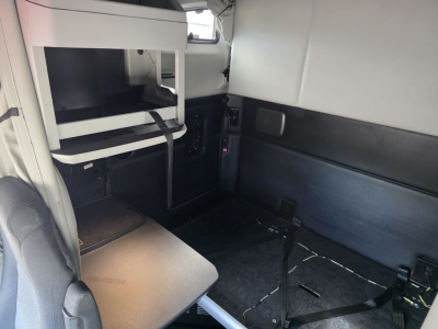 Kenworth T680 sleeper cab interior showing cabin bunk area with storage shelves and side paneling