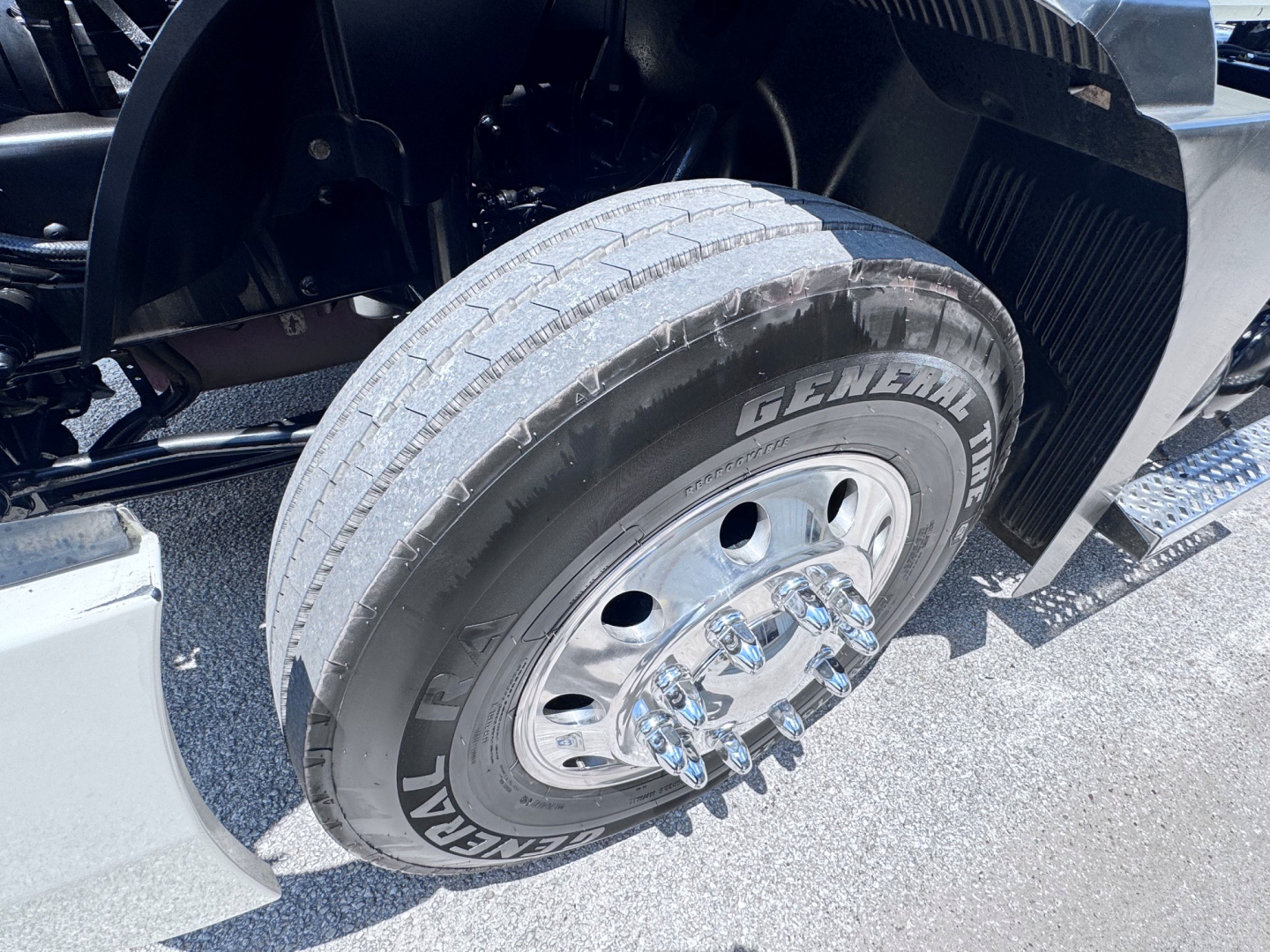 Mack Anthem truck front wheel showing GenUil General tire with hub and fender in a daytime setting.