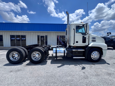 Side view of a white 2020 Mack Anthem conventional daycab truck chassis with dual rear axles and chrome fuel tanks.