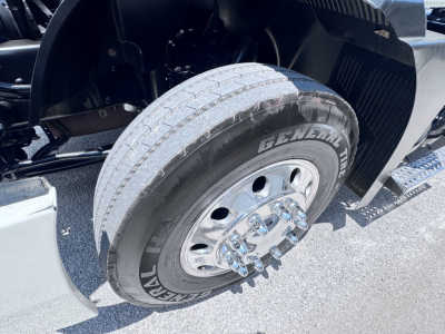 Mack Anthem truck front wheel showing GenUil General tire with hub and fender in a daytime setting.