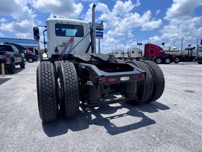Rear view of a semi truck tractor chassis showing dual rear axles, fifth wheel base, tires, and rear lights. No visible serials or decals readable from this angle.