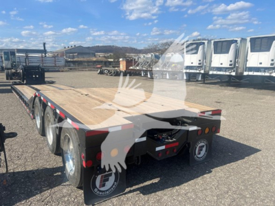 Fontaine Paver Pro lowboy trailer showing wooden deck, tandem axles, and rear lights with Fontaine logo on mudflaps.