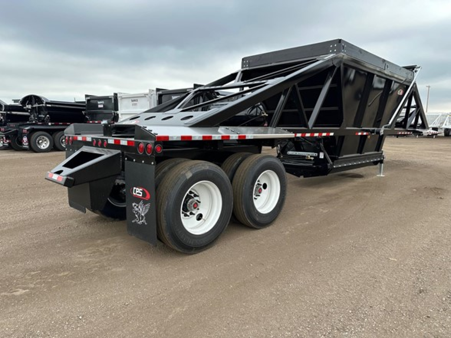 Cps light weight bottom dump trailer showing dual rear axles and hydraulic bed in lowered position, side rails and black frame visible.