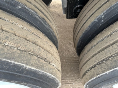 Trailer dual rear axles with six tires, close-up of tire treads and rims for a 2027 CPS light weight bottom dump.
