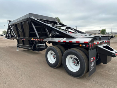 Low-angle view of a new 2027 CPS light weight bottom dump trailer with dual rear axles, open-top steel dump body, black frame, white wheels, and rear dump chute.