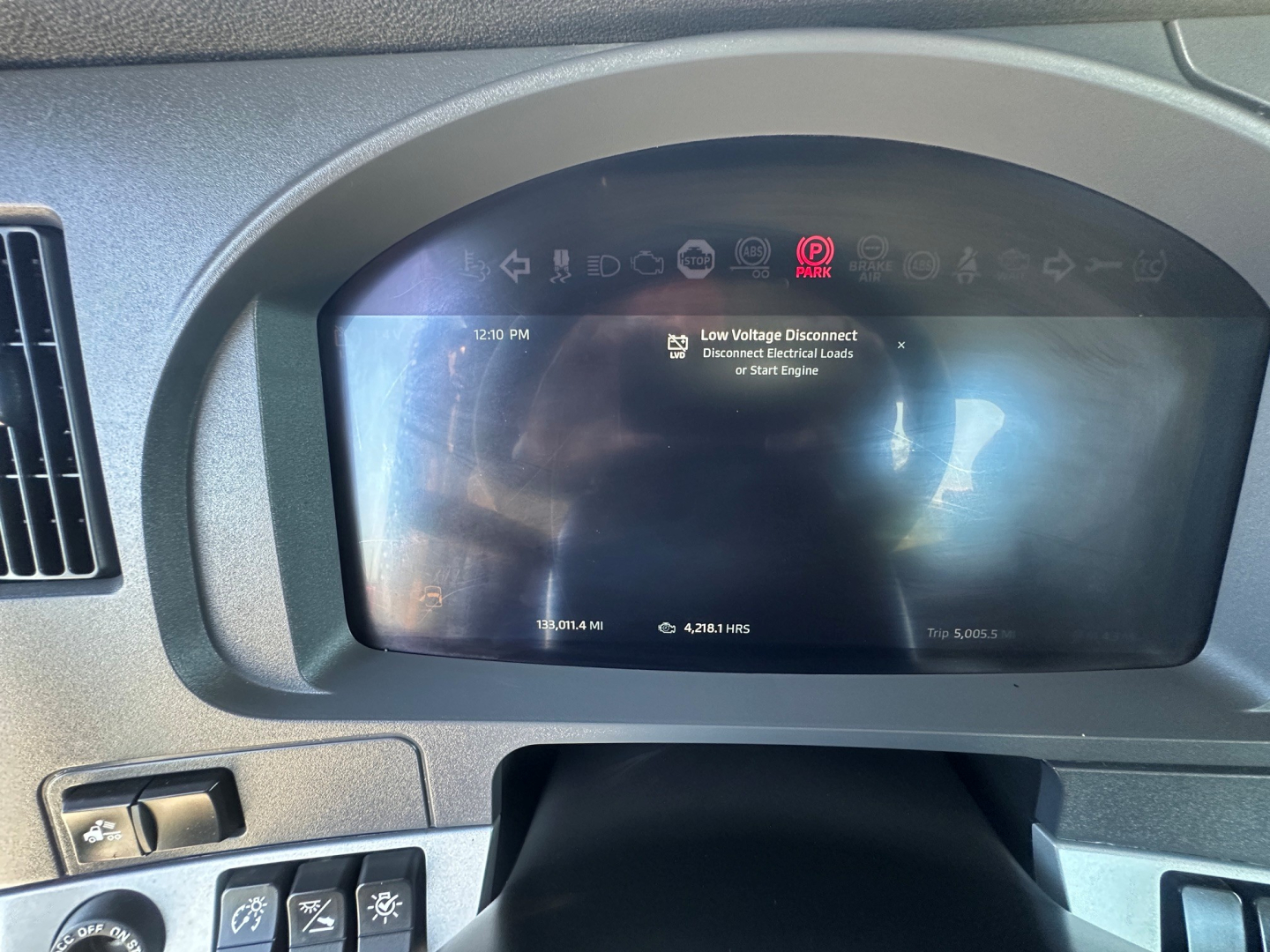 Kenworth T880 dashboard and digital instrument cluster showing a warning message; visible text includes Low Voltage Disconnect and Start Engine prompts on the screen.
