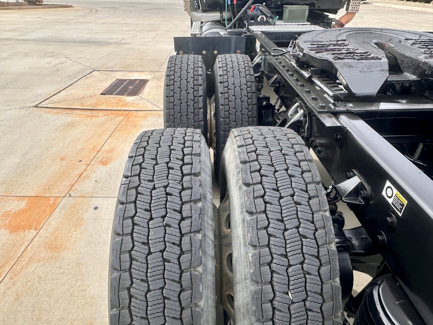 Kenworth T880 truck rear dual axle wheels and chassis showing tire tread and undercarriage components.