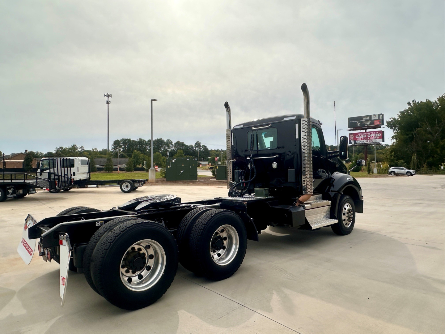 Kenworth T880 truck chassis and cab side view showing dual rear axles and fuel tanks, no cab interior visible.