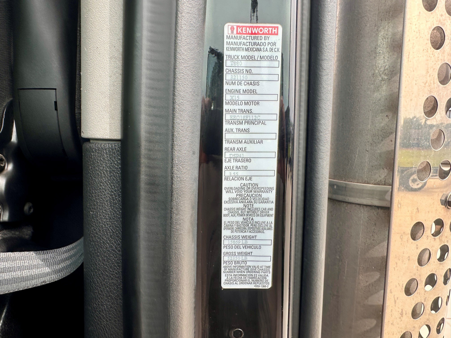 Kenworth T880 truck cab area with VIN/vehicle label visible showing manufacturing details and warnings.