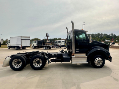 Kenworth T880 conventional daycab truck side view showing chassis and cab with dual rear axles and exhaust stacks.