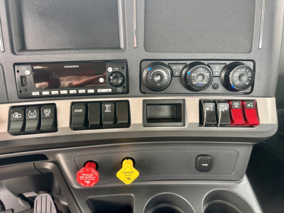 Kenworth T880 dashboard with radio, climate controls, and red/yellow warning indicators visible.