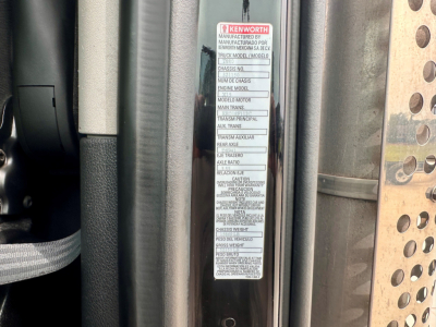 Kenworth T880 truck cab area with VIN/vehicle label visible showing manufacturing details and warnings.