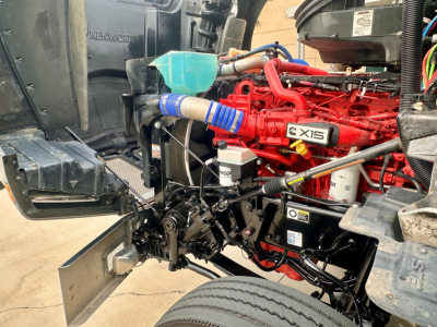 Kenworth T880 engine bay showing red X15 engine and surrounding components.