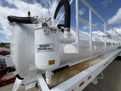 Trailers showing a white Troxell 130BBL vacuum trailer with drum daily vent, hose fittings, and label reading 'Troxell Trailer Mfg' on the cylindrical tank.