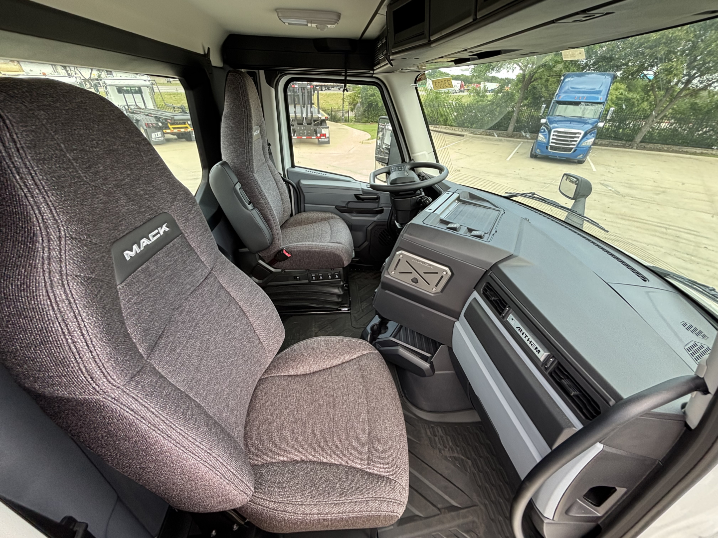 Mack AN64 truck cab interior showing driver's seat and dashboard with steering wheel and controls.