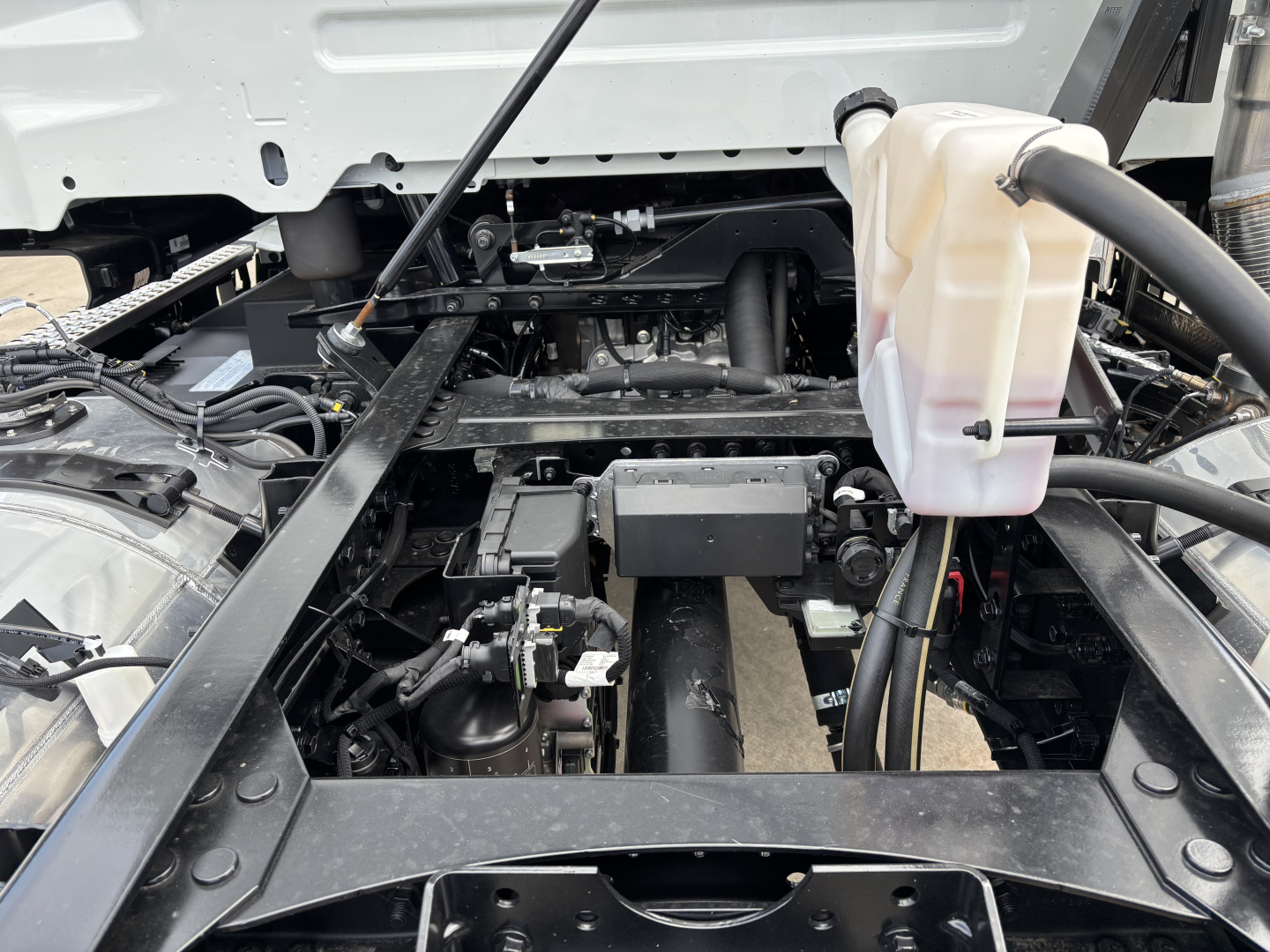AN64 Mack truck chassis showing coolant reservoir and engine bay components.
