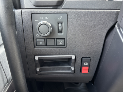 Dashboard controls and switch panel of a Mack AN64 truck showing headlight dial, auxiliary switches, a small storage slot, and a red SAVE button.
