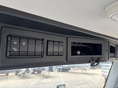 Dashboard overhead panel showing switches and a small open compartment with a key slot in a Mack AN64 truck cabin.