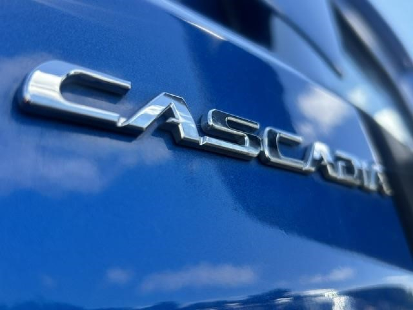Freightliner Cascadia badge on blue truck tailgate showing CASCADIA chrome lettering