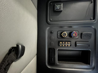 Cabin dash area of a 2022 Freightliner Cascadia 126 showing control panel with circular gauges, fuse block, and storage pocket in view.