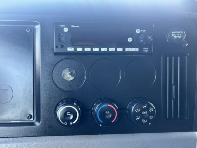 Dashboard of a 2022 Freightliner Cascadia 126 showing the radio unit, ventilation controls, and power outlet.