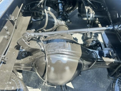 Freightliner Cascadia drivetrain view showing rear axle differential and suspension components in a sleepered truck.