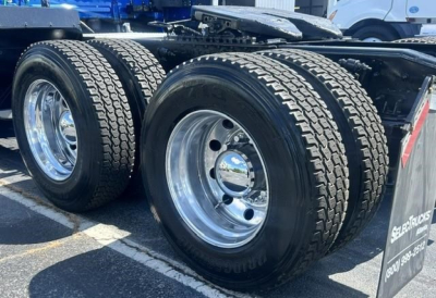Freightliner Cascadia rear dual rear axles showing polished aluminum wheels and heavy-duty tires.