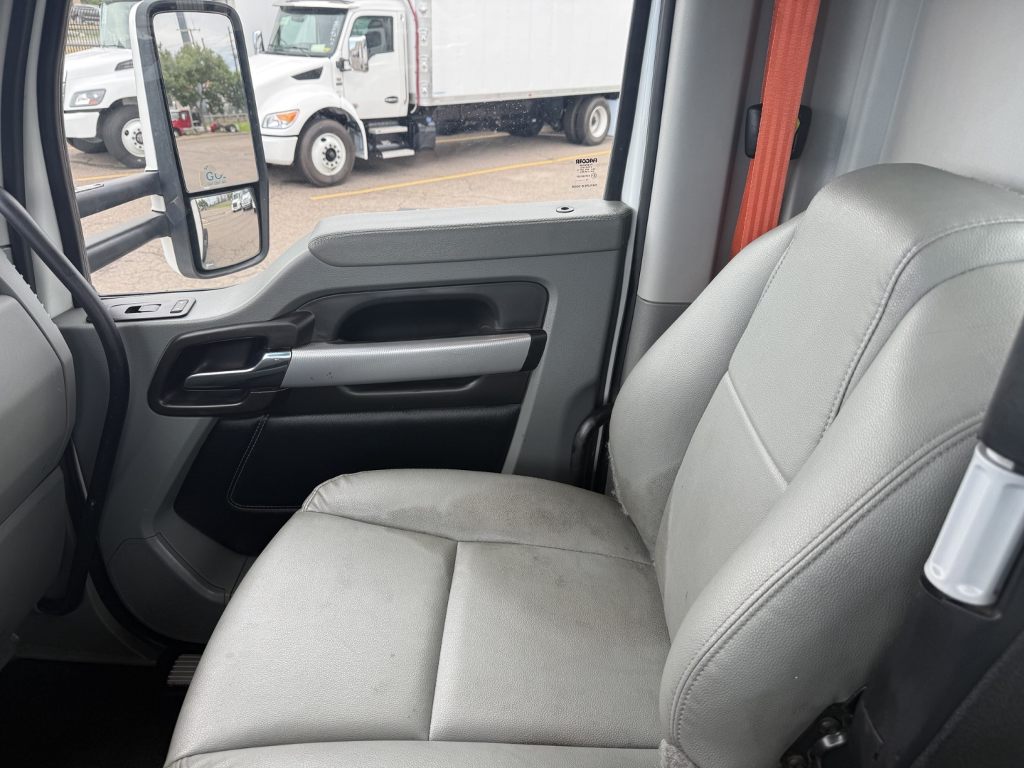 Kenworth T680 interior shot showing front passenger seat and door panel with window controls.