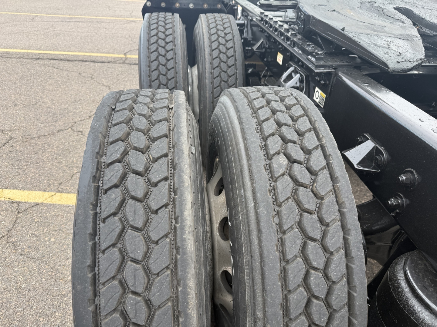 Kenworth T680 truck rear wheels with dual tires and chassis frame visible; no readable text on components.