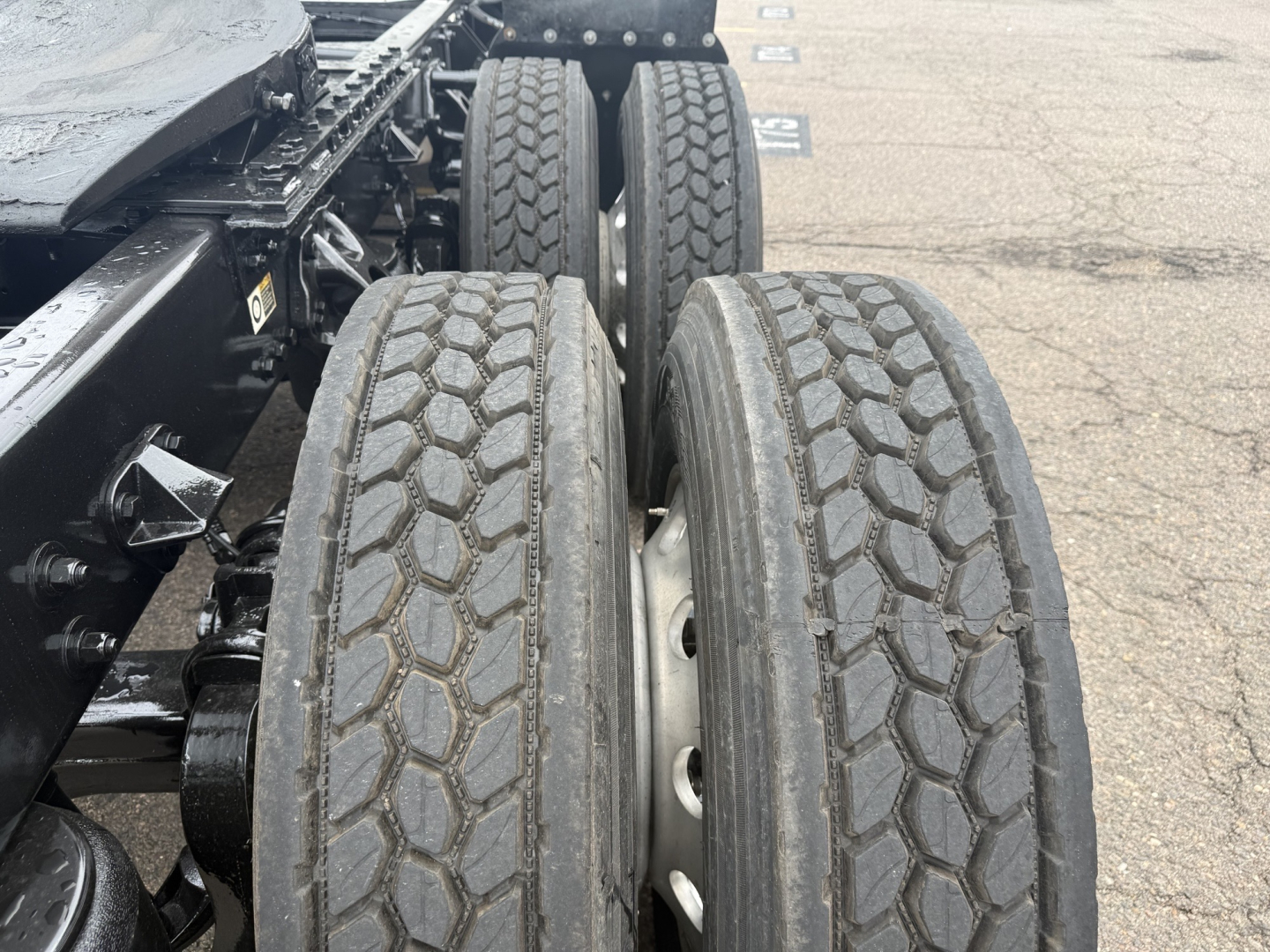 Kennworth T680 chassis with dual rear axles and treaded tires; visible components of wheel assembly