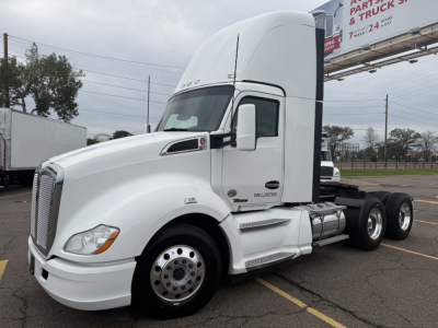 Kenworth T680 conventional daycab tractor in white, side view showing cab, fuel tanks, and front grille.