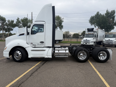 Kenworth T680 tractor cab side profile showing white exterior, dual rear axles, and fuel tanks.