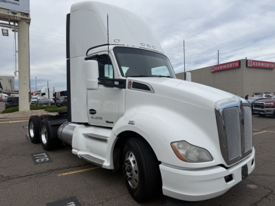 Kenworth T680 truck tractor in a parking lot, white cab, sleeper, dual rear axles, chrome grille, front fender markers, factory badging visible.