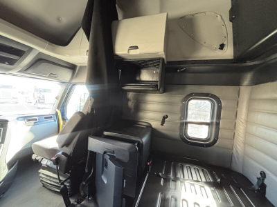 Cab interior of Freightliner PT126064ST sleeper tractor showing dashboard area, overhead storage, and side window