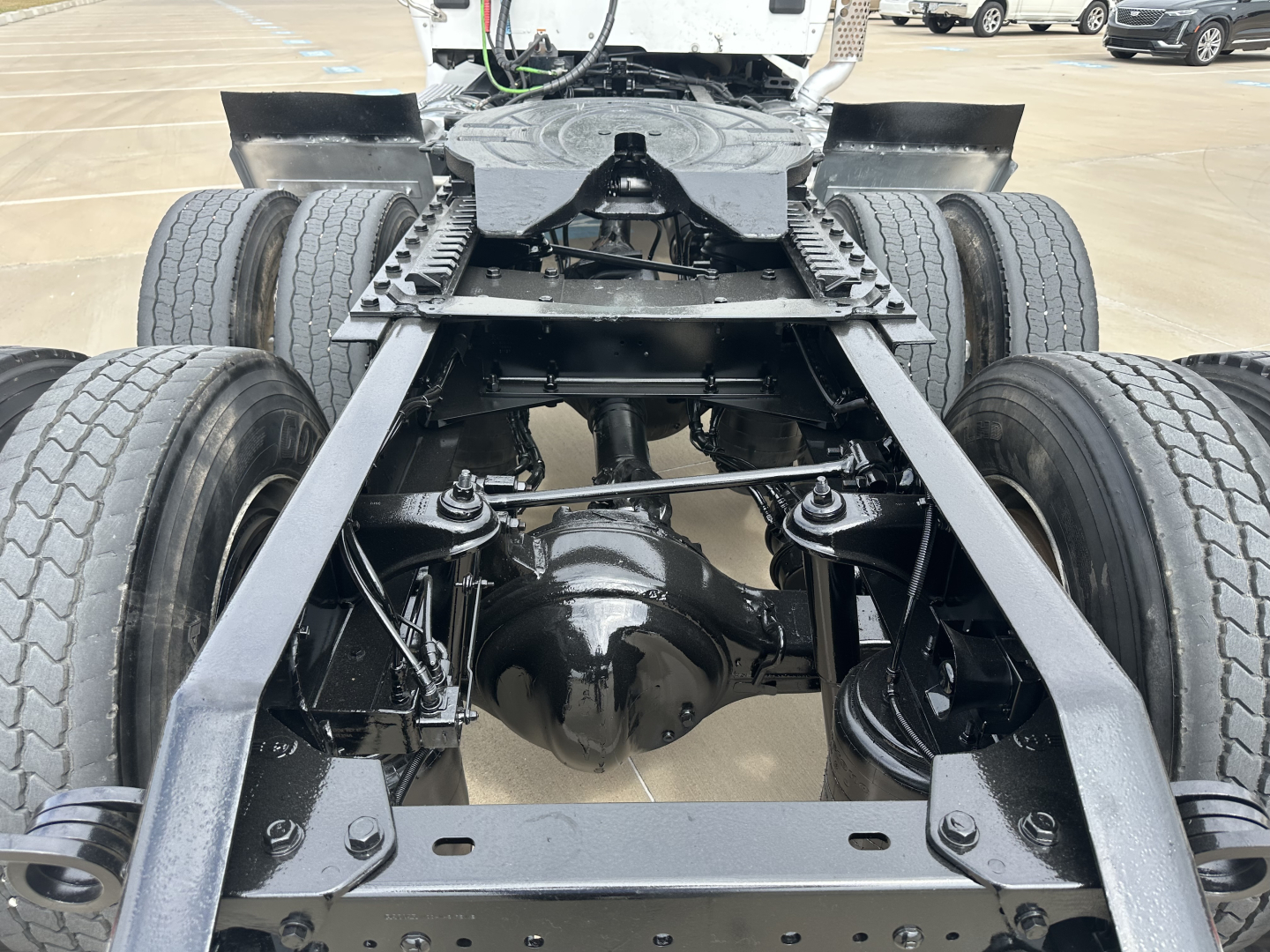 Kenworth T880 chassis and rear axle assembly showing dual rear wheels, driveshaft housing, and frame rails.