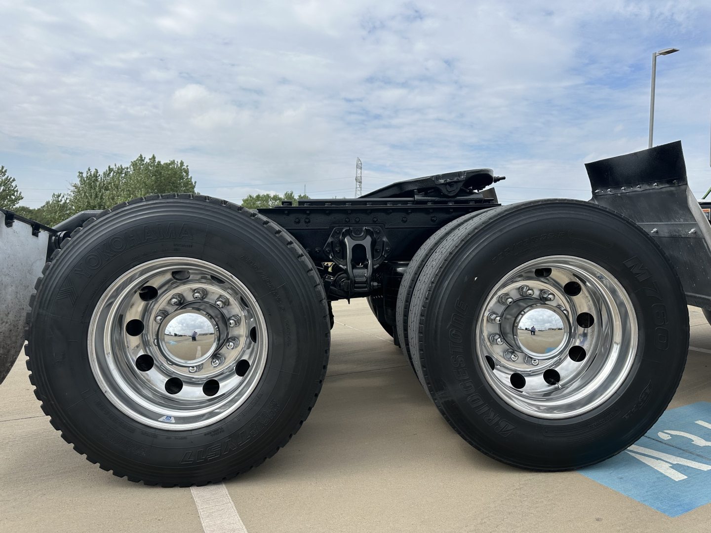 Kenworth T880 truck chassis showing dual rear axles and wheel rims with tires, no cabin visible.