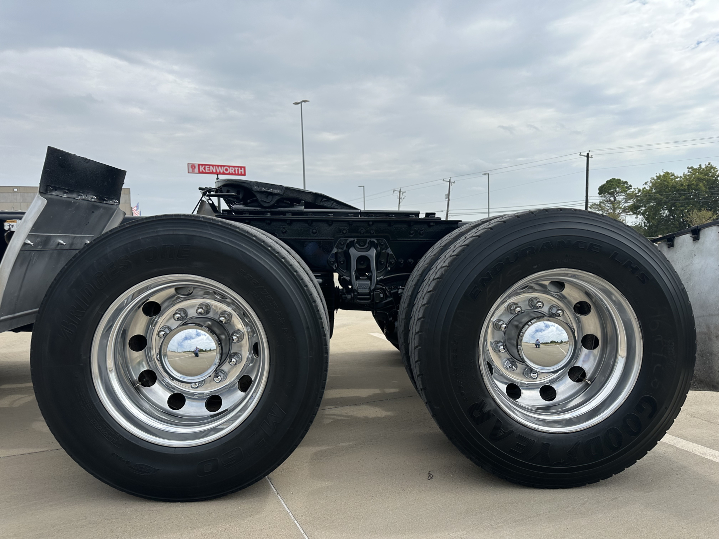 Dual rear truck wheels with chrome hubs and black tires; chassis frame visible between wheels.