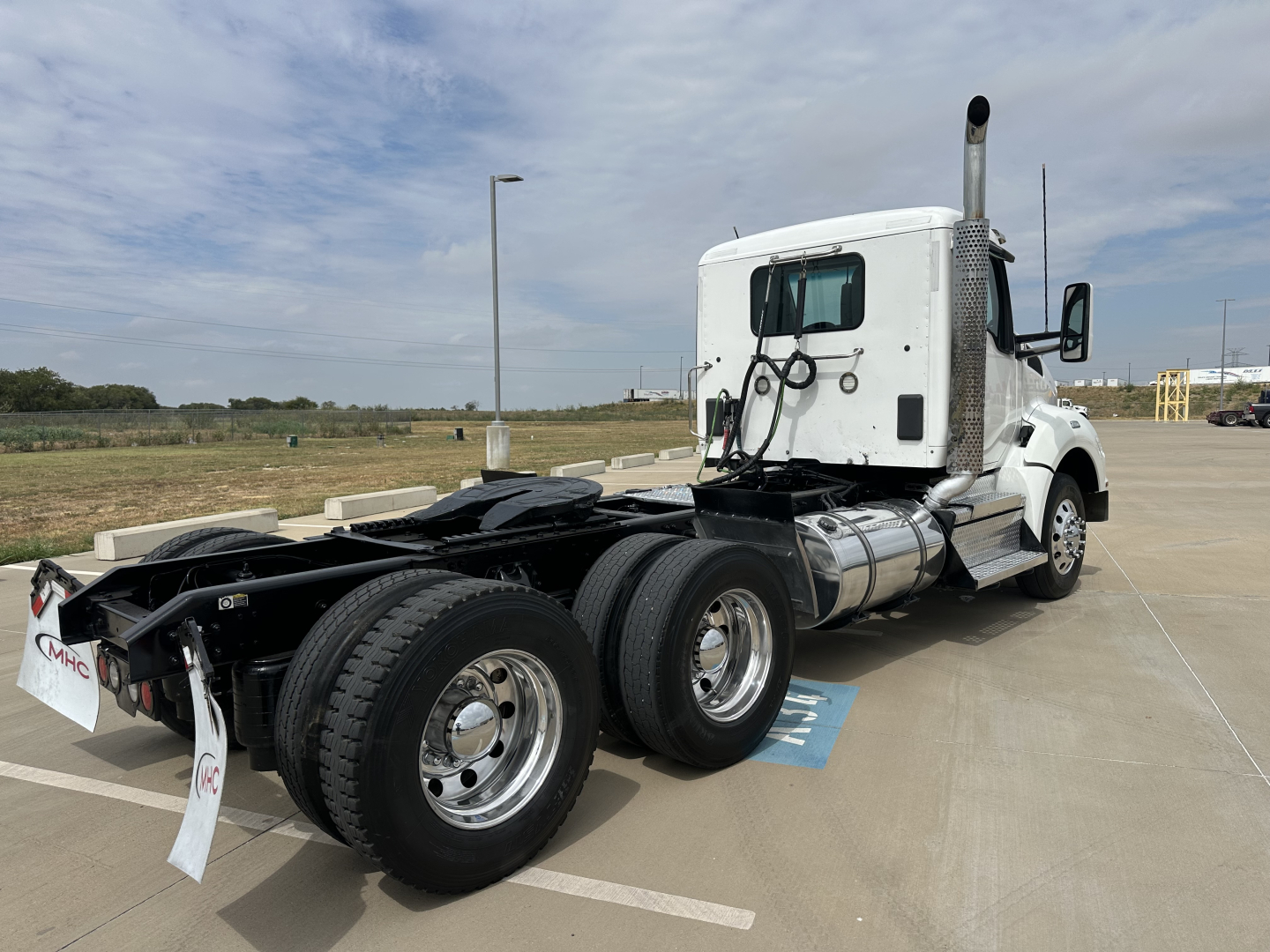 Kenworth T880 conventional daycab tractor rear chassis and fuel tanks showing dual rear axles and exhaust stack.