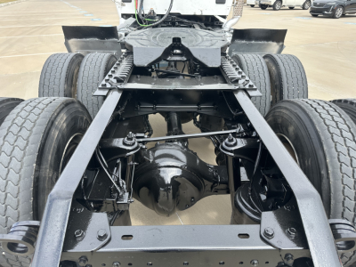 Kenworth T880 chassis and rear axle assembly showing dual rear wheels, driveshaft housing, and frame rails.