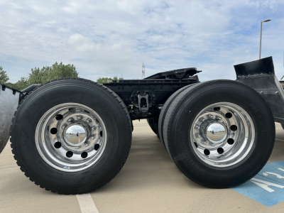Kenworth T880 truck chassis showing dual rear axles and wheel rims with tires, no cabin visible.