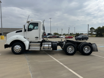 Kenworth T880 conventional daycab tractor in white, side view showing chassis, fuel tanks, and dual rear axles.