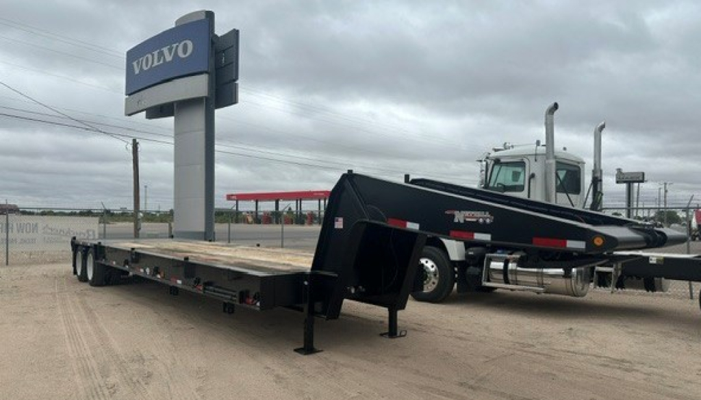 Lowboy trailer in a Volvo lot showing a 235LB Nuttall trailer with VIN 4C9LN4724VA061522 and stock 72521.