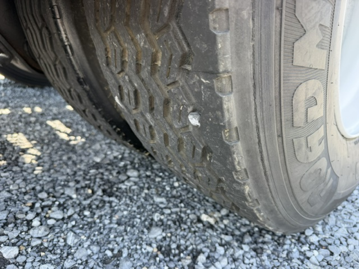 Tire close-up on a vehicle wheel with visible tread pattern and sidewall, part of a yard trucks listing.